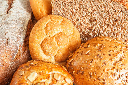 Assortment of traditional buns with a bundle of cereals, close up