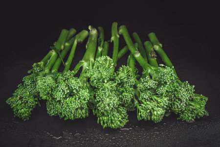 Fresh bimi vegetable on a dark table. Raw baby broccoli