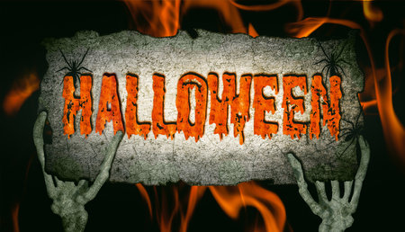 Human bone hands hold up a sign with the inscription Halloween.の写真素材