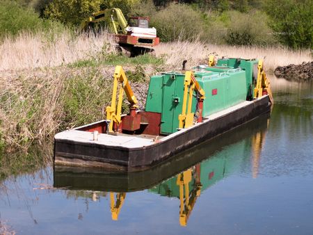 Dredging vessel moored up on canal side streamの写真素材