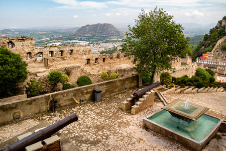 Xativa, Valenciana, Spain - Sept 17 2019 : View of Xativa small castle from walls of larger castle with tourists wandering around.のeditorial素材