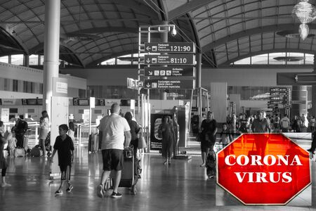 Busy airport lounge area with sign indicating warning of Coronavirus - infectious disease conceptのeditorial素材