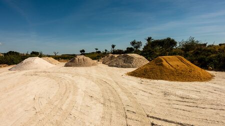 piles of sand, shingle and rubble by roadside ready for useの写真素材