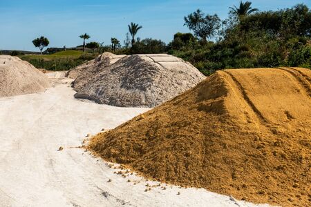 piles of sand, shingle and rubble by roadside ready for useの写真素材