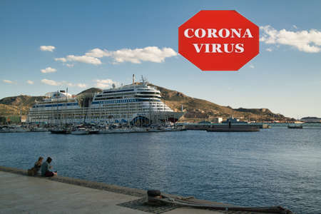 Cartagena, Valenciana, Spain - Mar 2020 : Large cruise ship at port with sign indicating warning of Coronavirus - infectious disease conceptのeditorial素材