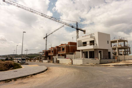 Torrevieja, Valenciana, Spain - May 08 2020 : new homes under construction on spanish urbanisation with cranesのeditorial素材