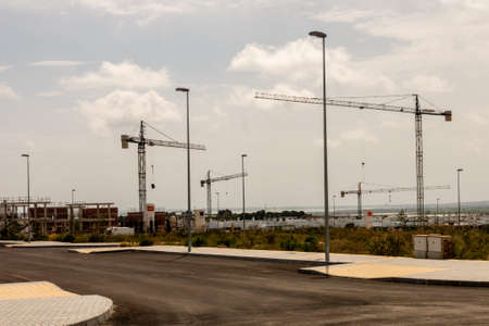 Torrevieja, Valenciana, Spain - May 08 2020 : new homes under construction on spanish urbanisation with cranesのeditorial素材