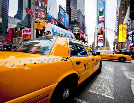 NEW YORK - DECEMBER 17: Yellow cab speeds through Times Square the busy tourist intersection of neon...