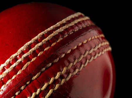 Red Leather Cricket Ball on blackの写真素材