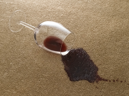 Glass of red wine on carpetの写真素材