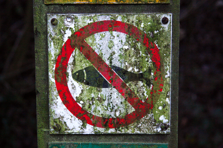 This sign located by the side of a canal tells that fishing is prohibited. Due to overhead cables. Worcestershire, UKの写真素材
