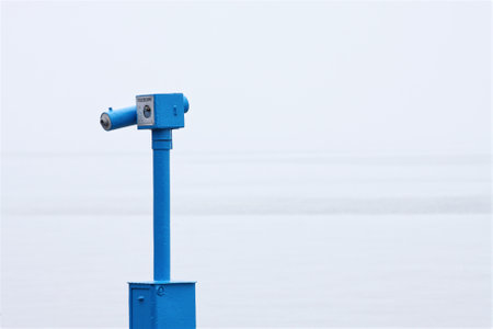 Telescope looks out upon hazy sea view at British seasideの写真素材