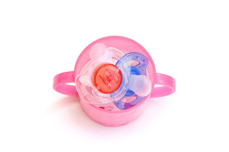 Dummies in a pink beaker. Red, white and blue colours. The small bubbles are the result of the dummies having being sterilised.の写真素材