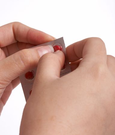 popping a pill out of it's packageの写真素材