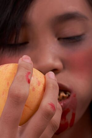 A vampire with a bloody mouth holding an appleの写真素材