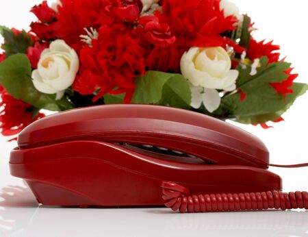 Photo of a telephone with some flowers on the backgroundの写真素材