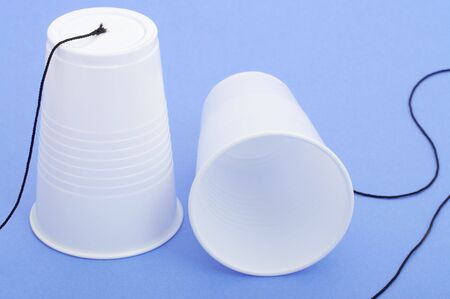 a photo of a string telephone over a blue backgroundの写真素材