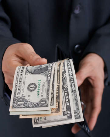 businessman holding a wallet with dollar bills