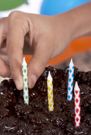 baked chocolate cake with four candles on top