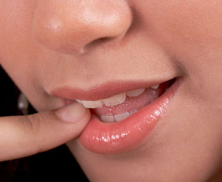 lady finger pointing her lips with glossの写真素材