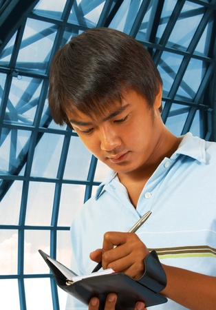 Business Man Making Notes In His Planner At A Convention Centerの写真素材