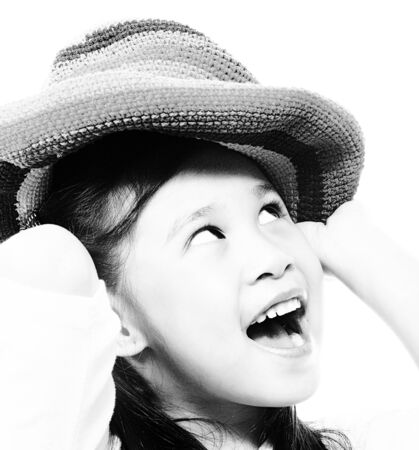 Smiling And Happy Girl Putting On A Floppy Hatの写真素材