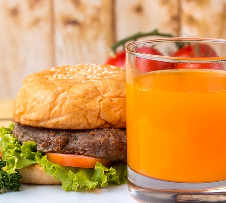 Burger And Juice Representing Orange Drink And Bbqの写真素材
