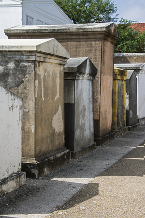 Weathered above ground burial vaults in the St  Louis Cemetery Number 1 in New Orleans, Louisiana cast shadows on the path that runs in front of themの写真素材