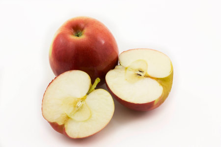 Two half apples and whole apple sliced on a white backgroundの写真素材