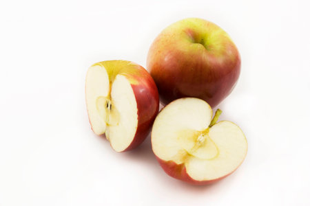 Two half apples and whole apple sliced on a white backgroundの写真素材