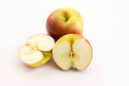 Two half apples and whole apple sliced on a white backgroundの写真素材