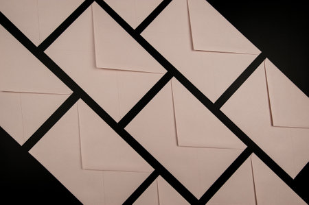 Top view of light pink envelopes on black background. Post flat lay. Copy space.の写真素材