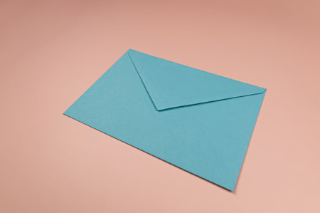 Light blue envelope on pink background. One envelope flat lay. Copy space. Post.の写真素材
