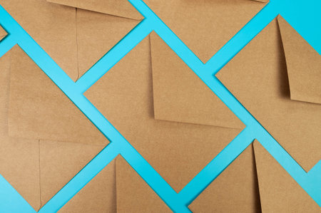 Top view of brown kraft envelopes on blue background. Post flat lay. Copy space.の写真素材