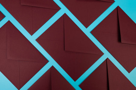 Top view of dark red envelopes on blue background. Post flat lay. Copy space.