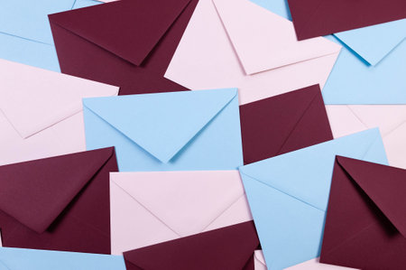 Top view of colourful envelopes. Pink, blue and dark red envelopes flat lay. Copy space.の写真素材
