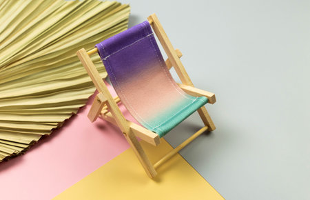 Colorful beach chair, dried palm leaf on colorful background. Summer, holidays and beach concept. Creative composition, copy space.の写真素材