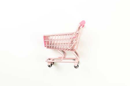 Top view of pink shopping trolley on white background. Creative shopping wallpaper, sale. Copy space, flat lay.の写真素材