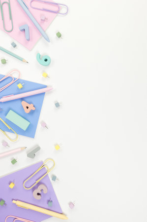 Top view of pink, purple and blue notebooks on white background. Colorful pens, pencils, paperclips, numbers and pins. School, office wallpaper. Flat lay, copy space.の写真素材