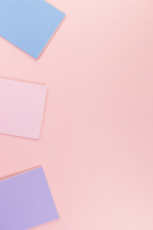 Top view of pink, purple and blue notebooks on pink background. School, office wallpaper. Flat lay,...