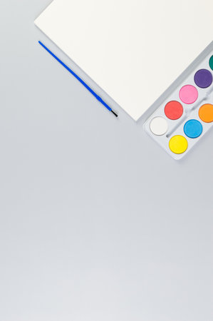 Top view of watercolor, paper and paint brush on grey background. Painting, art, copy space, flat lay.の写真素材