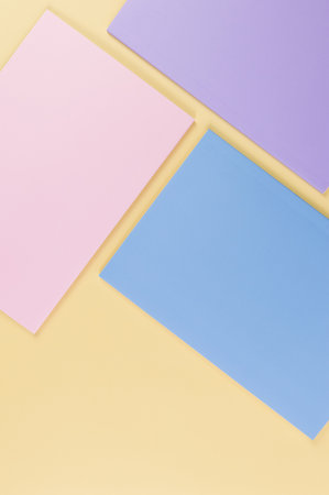 Top view of pink, purple and blue notebooks on yellow background. School, office wallpaper. Flat lay, copy space.の写真素材