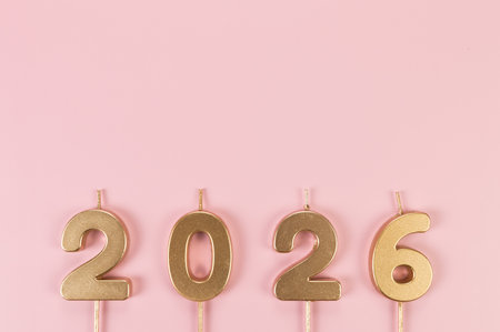 2026 Happy New Year. Top view of gold numbers on pink background. Copy space, flat lay.の写真素材