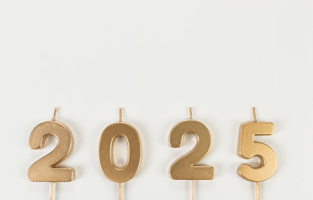 2025 Happy New Year. Top view of gold numbers on white background. Copy space, flat lay.