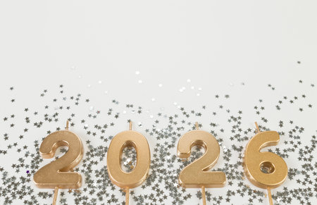 2026 Happy New Year. Top view of gold numbers, silver stars confetti on white background. Copy space, flat lay.の写真素材