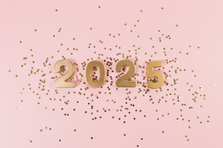 2025 Happy New Year. Top view of gold numbers, gold stars confetti on pink background. Copy space, flat lay.の写真素材