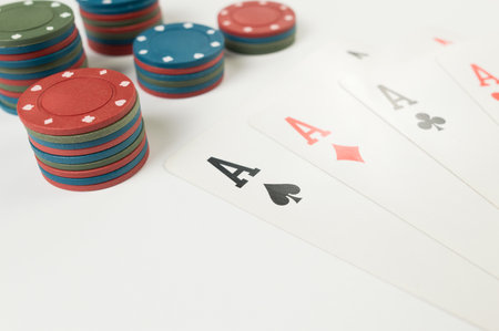 Top view of playing cards, poker chips on white background. Four aces cards, board game, poker. Copy...