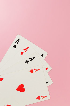 Top view of playing cards on pink background. Four aces cards, board game, poker. Copy space, flat...