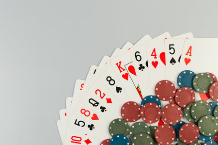 Top view of playing cards, poker chips on grey background. Lot of cards, board game, poker. Copy...