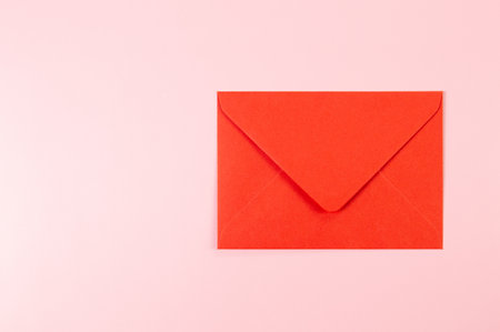 Top view of red envelope on pink background. Post flat lay. Copy space.の写真素材